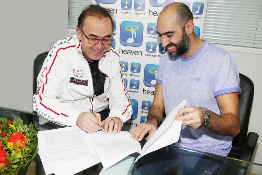 Ο Σταμάτης Γονίδης υπογράφει το συμβόλαιο με τον διευθυντή της Heaven Music, Σπύρο Σταμούλη.